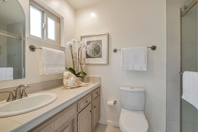 bathroom with vanity, an enclosed shower, and toilet