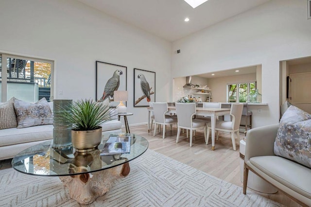 living room featuring a high ceiling and light hardwood / wood-style flooring