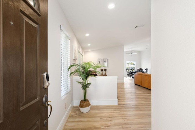 foyer entrance featuring ceiling fan, light hardwood / wood-style flooring, and vaulted ceiling