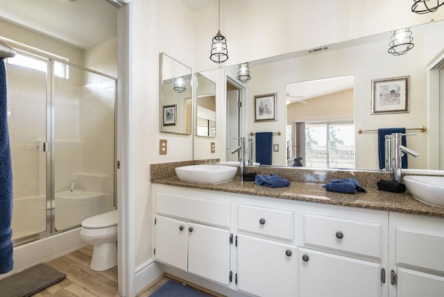 bathroom with vanity, ceiling fan, hardwood / wood-style floors, toilet, and a shower with shower door