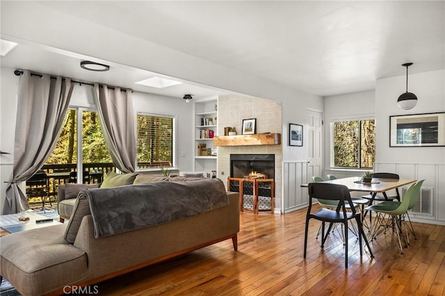 living room featuring a wealth of natural light, built in features, and wood-type flooring