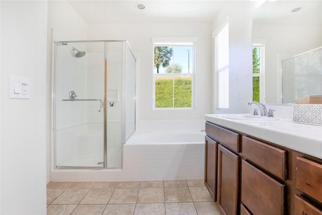 bathroom with a bath, a shower stall, tile patterned flooring, and vanity