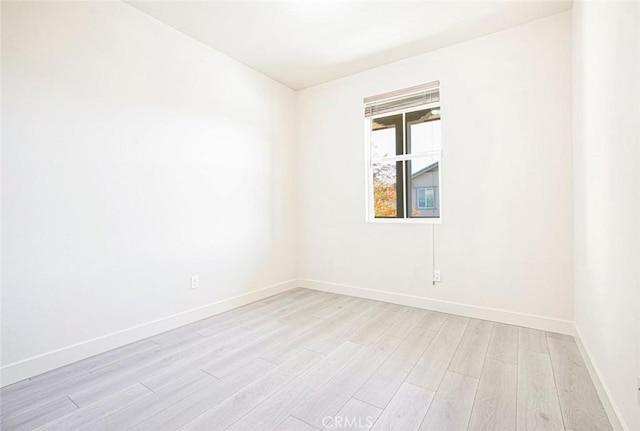 unfurnished room featuring light wood-style flooring and baseboards