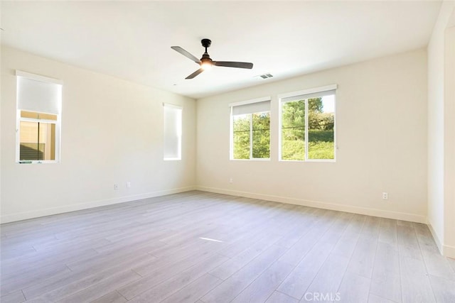 unfurnished room featuring baseboards, visible vents, and light wood finished floors