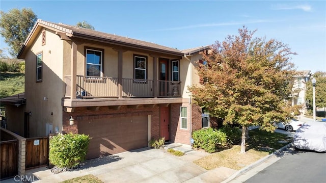 townhome / multi-family property featuring brick siding, stucco siding, an attached garage, a balcony, and driveway