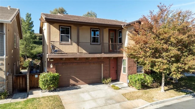 view of front of property featuring a garage, driveway, brick siding, and stucco siding