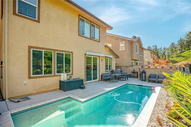 view of pool with fence, an outdoor living space, a fenced in pool, and a patio