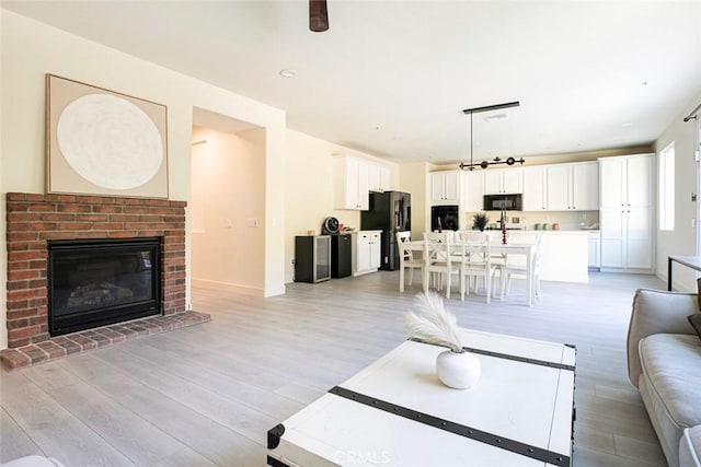 living area with light wood-style flooring and a fireplace