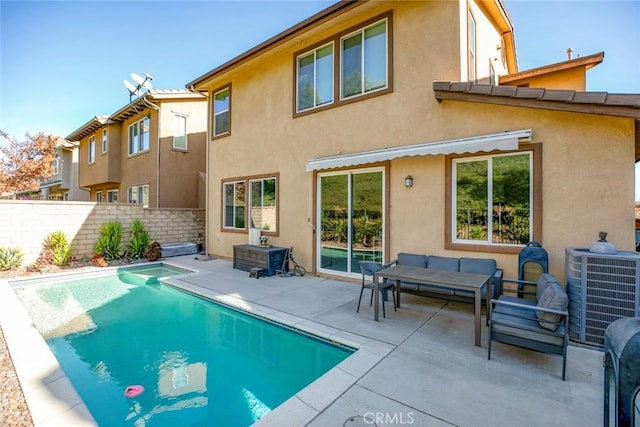 back of property with outdoor lounge area, central AC unit, a patio area, and a fenced in pool