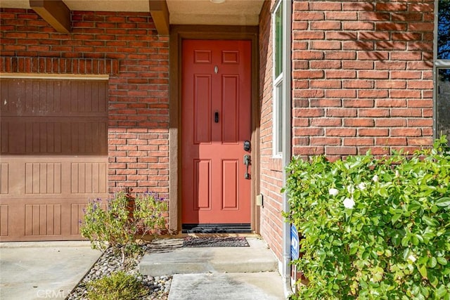 view of exterior entry with brick siding