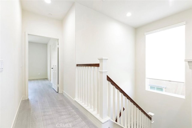 hall featuring baseboards, recessed lighting, an upstairs landing, and light wood-style floors