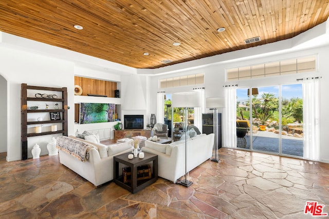 living room featuring a large fireplace and wood ceiling