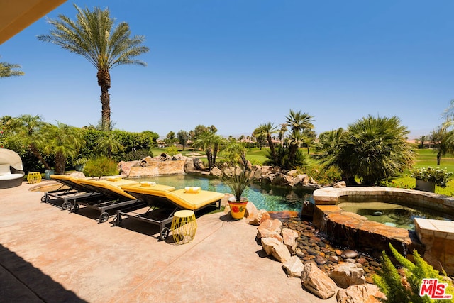 exterior space featuring an in ground hot tub and a patio