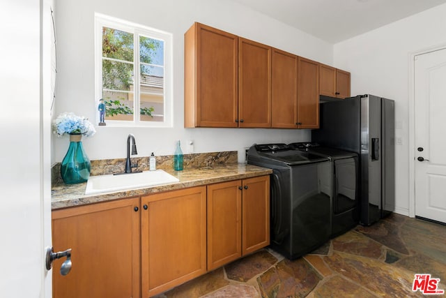 laundry area featuring cabinets, washing machine and dryer, and sink