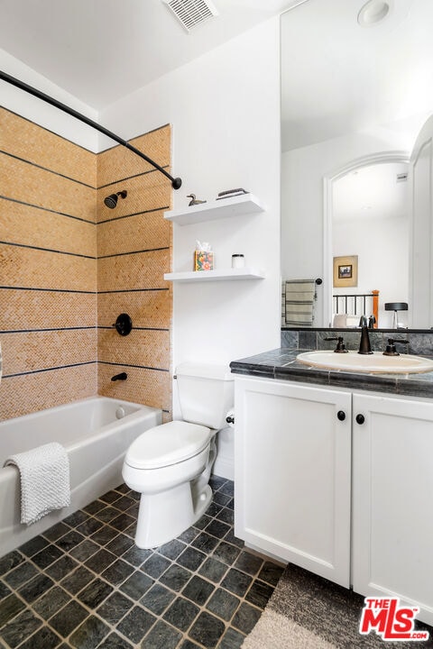 full bathroom with vanity, tiled shower / bath combo, and toilet