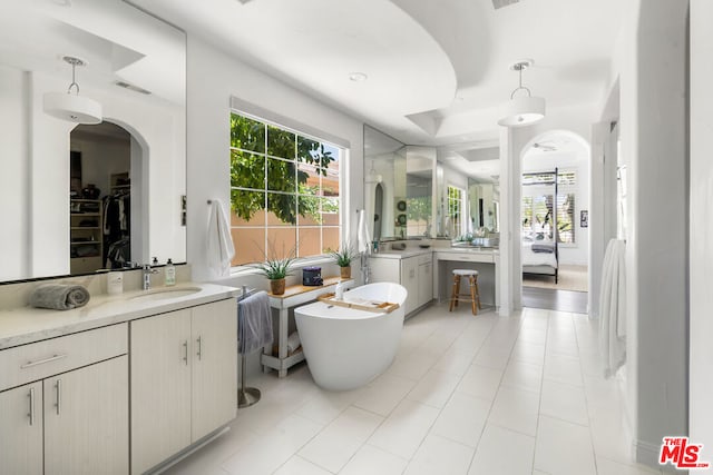 bathroom with tile patterned floors, vanity, and a tub