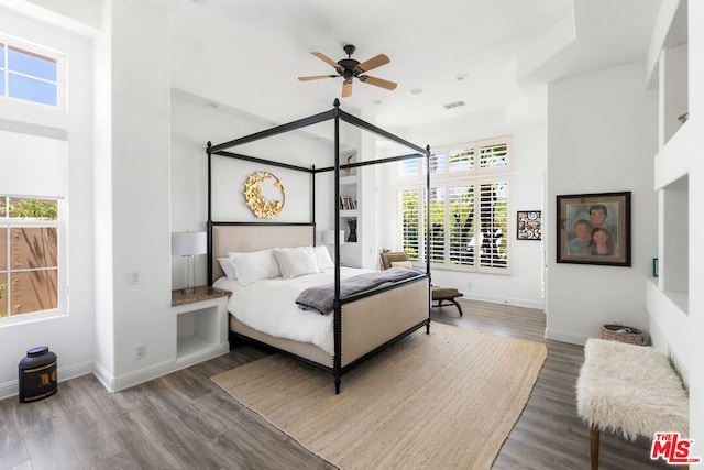 bedroom with hardwood / wood-style floors, ceiling fan, and multiple windows