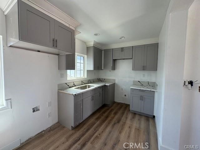 kitchen with gray cabinetry, sink, and dark wood-type flooring