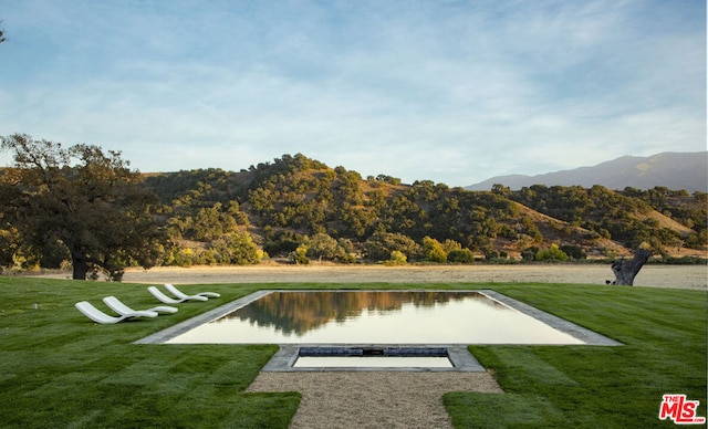 view of property's community featuring a yard and a water and mountain view