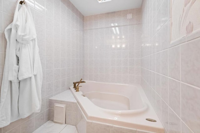 bathroom featuring tile walls and tiled bath