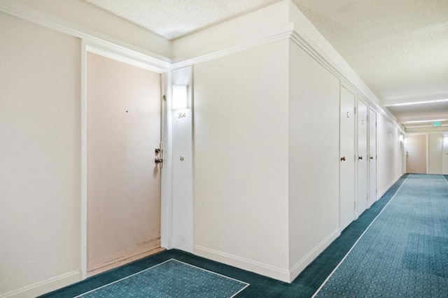 hallway with ornamental molding and a textured ceiling