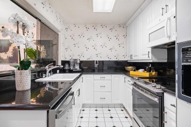 kitchen with sink, range with electric cooktop, white cabinets, light tile patterned flooring, and stainless steel dishwasher