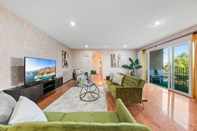 living room with light hardwood / wood-style floors and a textured ceiling