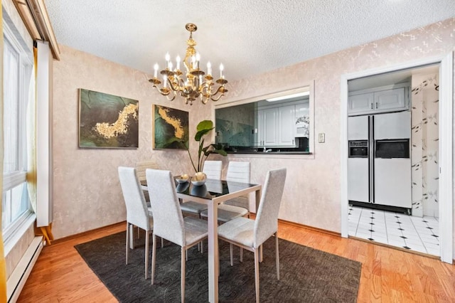 dining space featuring baseboard heating, a chandelier, hardwood / wood-style floors, and a textured ceiling