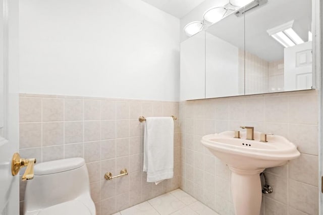 bathroom with tile walls, tile patterned floors, and toilet