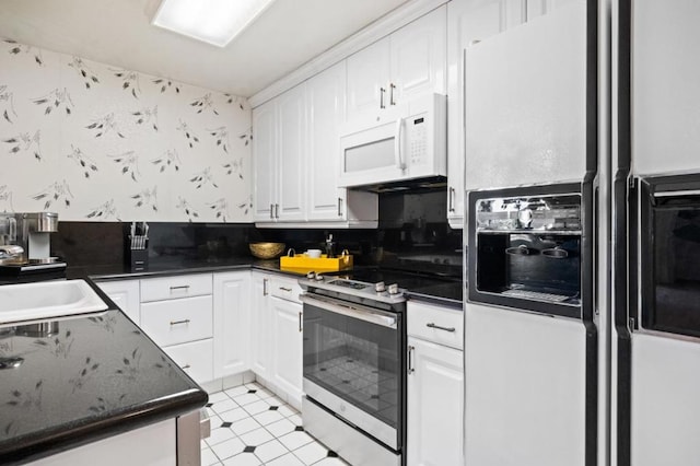 kitchen with white cabinetry, sink, white appliances, and light tile patterned floors