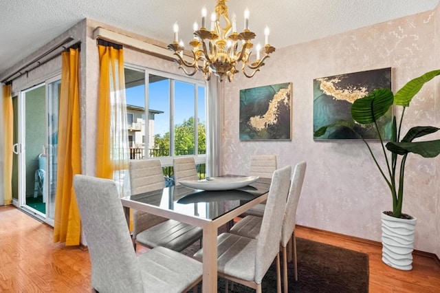 dining area featuring an inviting chandelier, hardwood / wood-style floors, and a textured ceiling