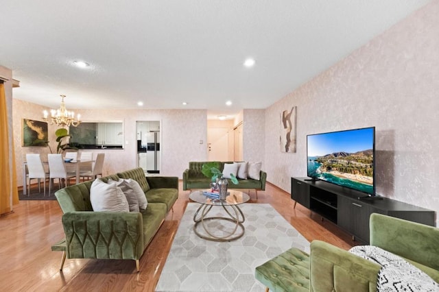 living room with an inviting chandelier and light hardwood / wood-style flooring