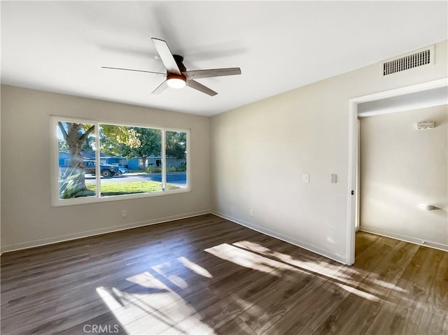 empty room featuring ceiling fan and dark wood-type flooring