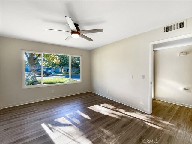 unfurnished room featuring dark wood-type flooring and ceiling fan