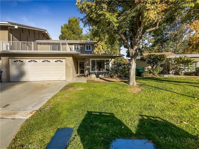 view of front property featuring a balcony, a front lawn, and a garage