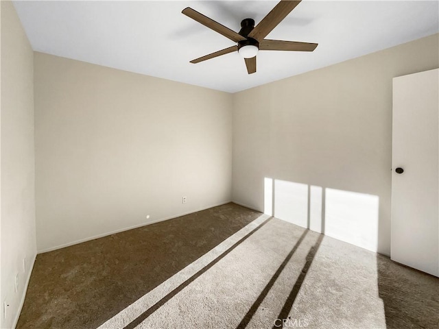 unfurnished room featuring dark carpet and ceiling fan