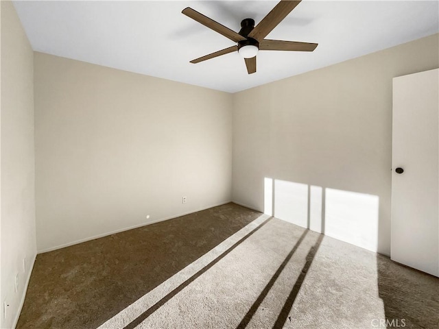 unfurnished room with ceiling fan and dark carpet