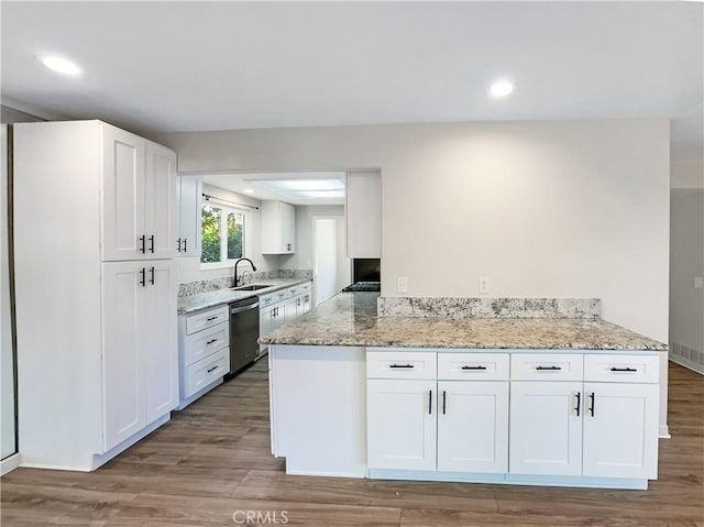 kitchen featuring sink, stainless steel dishwasher, light wood-type flooring, white cabinetry, and kitchen peninsula