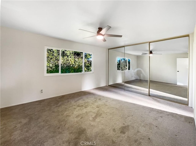 unfurnished bedroom with carpet floors, a closet, and ceiling fan