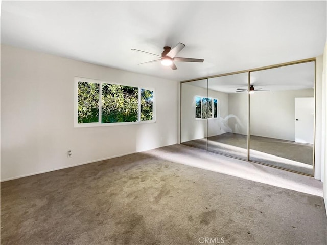 unfurnished bedroom with carpet floors, ceiling fan, and a closet