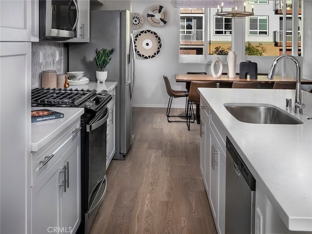 kitchen featuring white cabinetry, sink, appliances with stainless steel finishes, and dark wood-type flooring