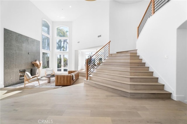 stairs with a high ceiling and hardwood / wood-style flooring