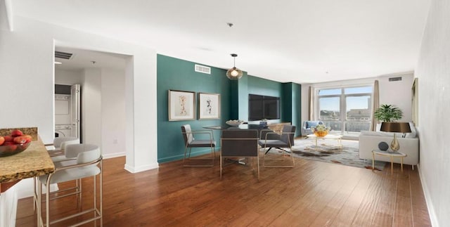 interior space featuring hardwood / wood-style flooring and stacked washer / dryer