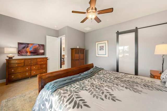 bedroom with tile patterned flooring, ceiling fan, and a barn door