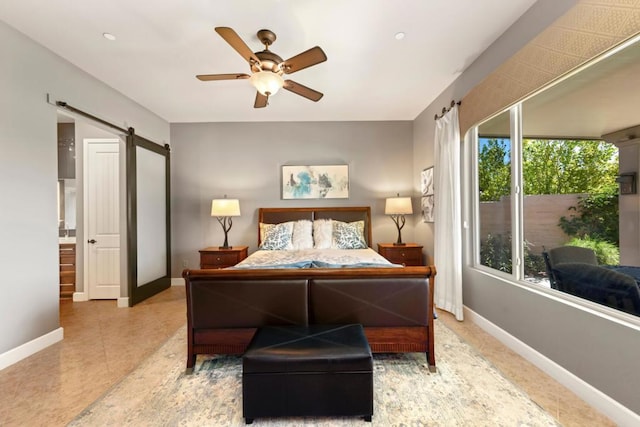 bedroom with ceiling fan and a barn door