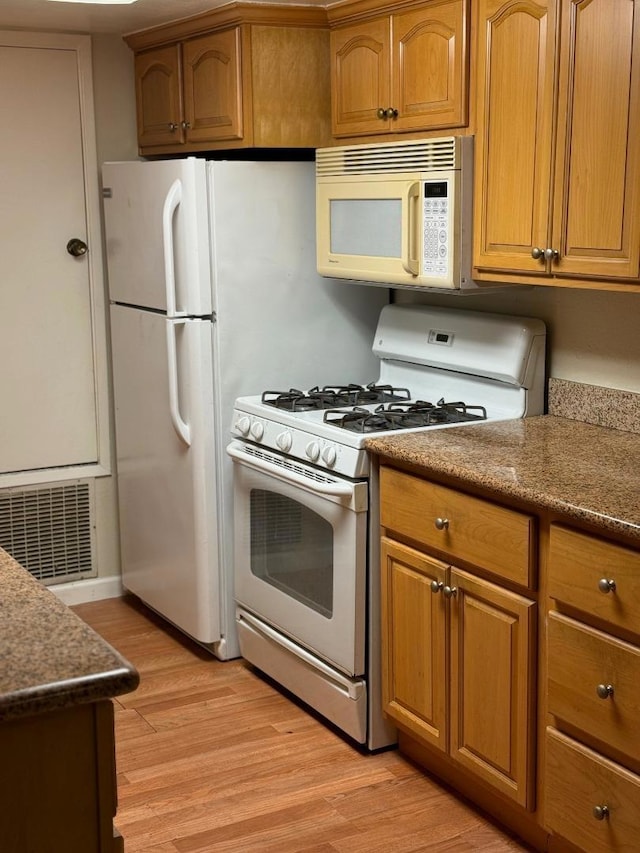 kitchen featuring white appliances and light hardwood / wood-style flooring