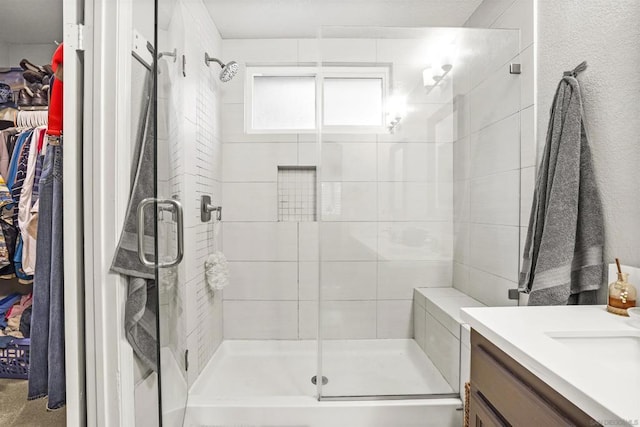 bathroom with vanity and a shower with door