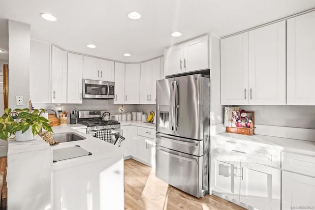 kitchen featuring light wood-type flooring, white cabinetry, sink, and appliances with stainless steel finishes