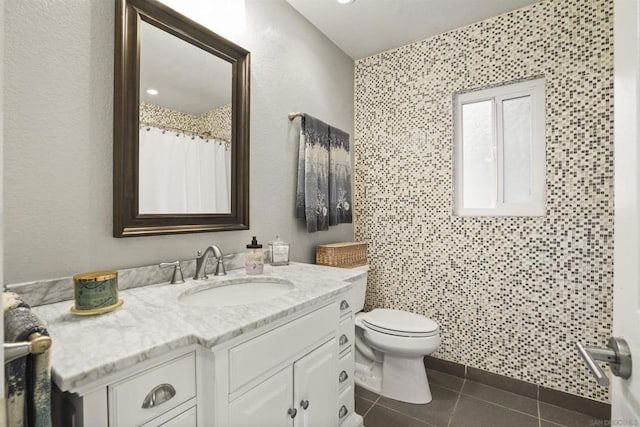 bathroom with toilet, vanity, and tile patterned floors