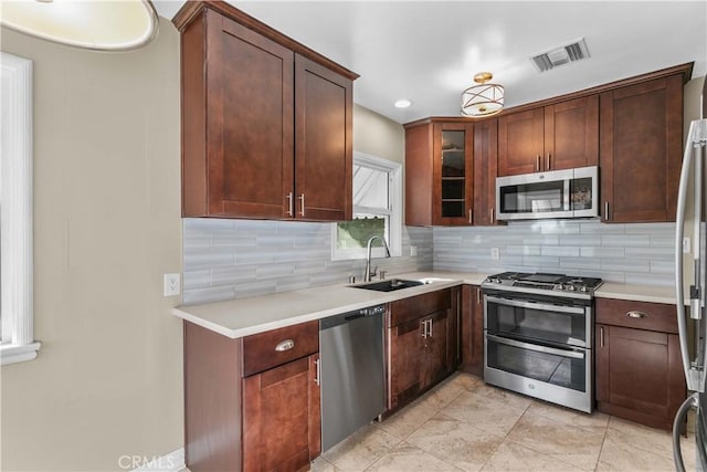 kitchen featuring decorative backsplash, appliances with stainless steel finishes, and sink